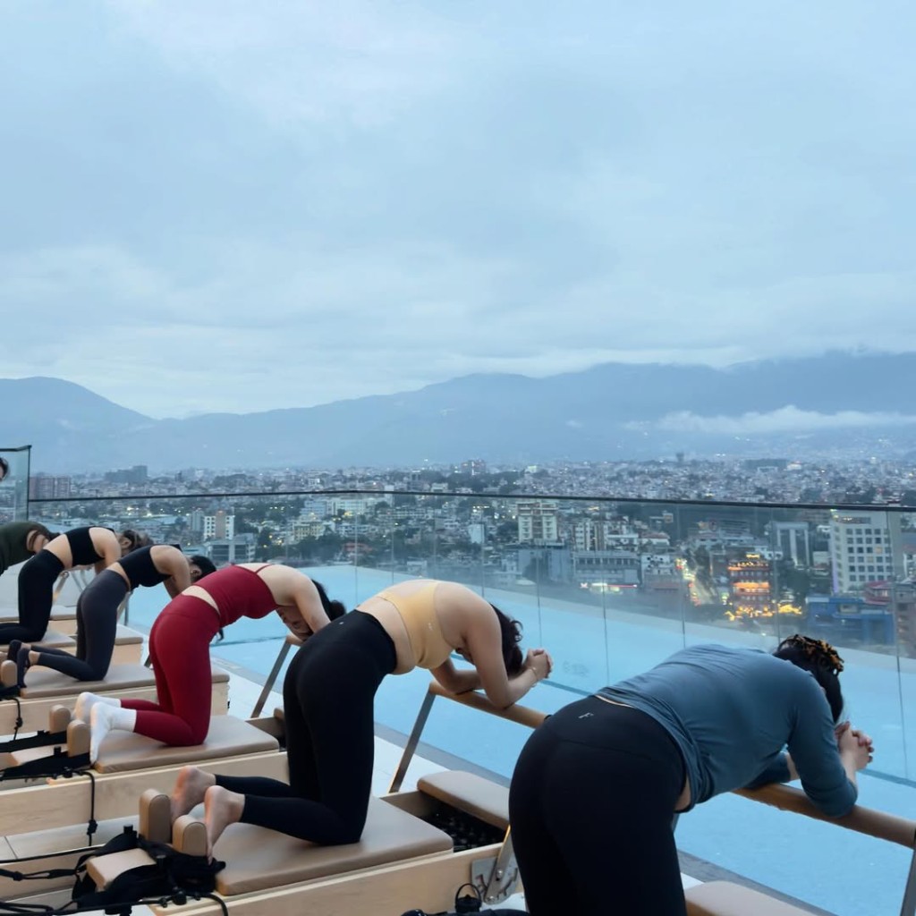 Rooftop Reformer class at CoreFlow with city and mountain views